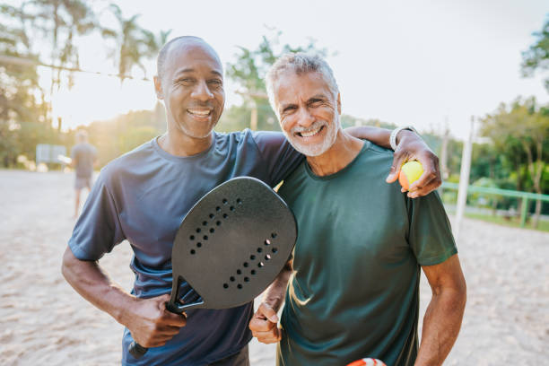 istock Two senior friends playing beach tennis 1486147905