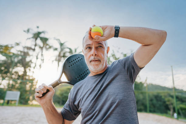 istock Senior man playing beach tennis tired wiping sweat 1486148073