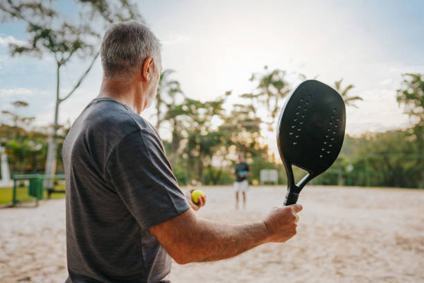 istock Senior men practicing beach tennis moment of serve 1486148854
