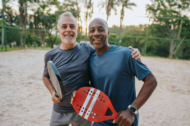 istock Two senior friends playing beach tennis 1486149141