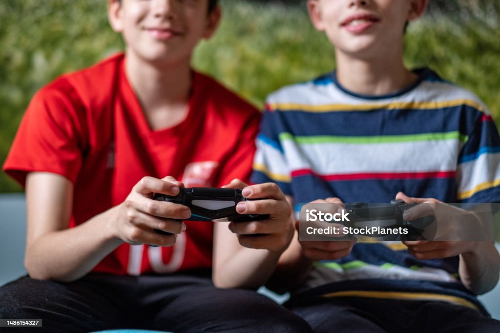 boys playing PlayStation boys playing PlayStation in the room Leisure Activity Stock Photo