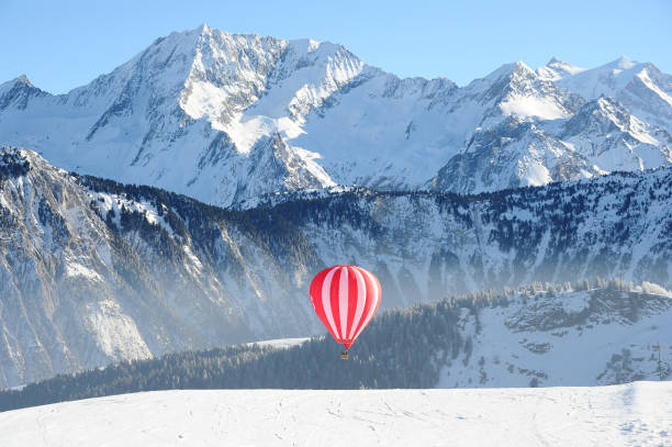 balão de ar quente nas encostas da estação de esqui de courchevel no inverno com a montanha mont blanc atrás - mont blanc ski slope european alps mountain range - fotografias e filmes do acervo