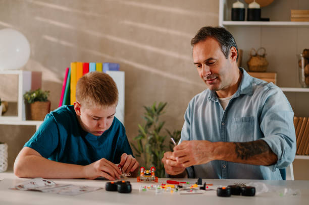 istock A young son and and his proud father assembling a small toy pieces together. 1486163825