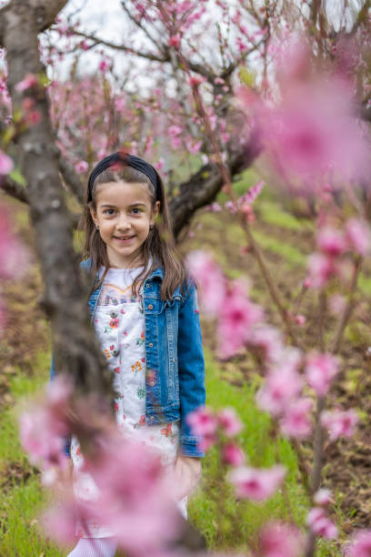 istock Little girl poses between spring blossom branch 1486166756