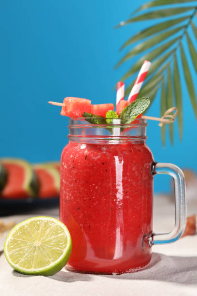 istock Tasty watermelon drink with lime in mason jar on sand 1486168763