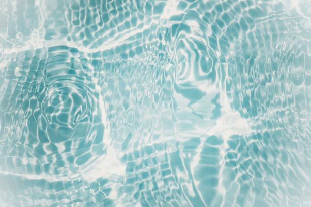 istock Blue water with ripples on the surface. Defocus blurred transparent blue colored clear calm water surface texture with splashes and bubbles. Water waves with shining pattern texture background. 1486169258