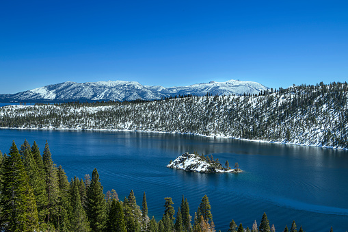 Winter view of Emerald Bay with Fannette Island in the middle and snow covered mountains in background.\n\nTaken from the Western Shore of Lake Tahoe, California, USA  looking East.