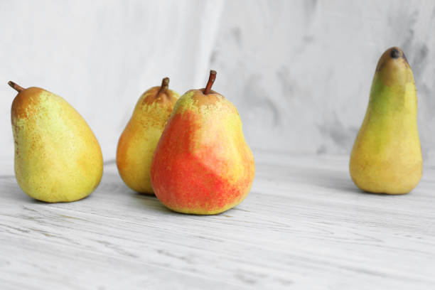 Juicy pears and double-sided backdrop on table in photo studio