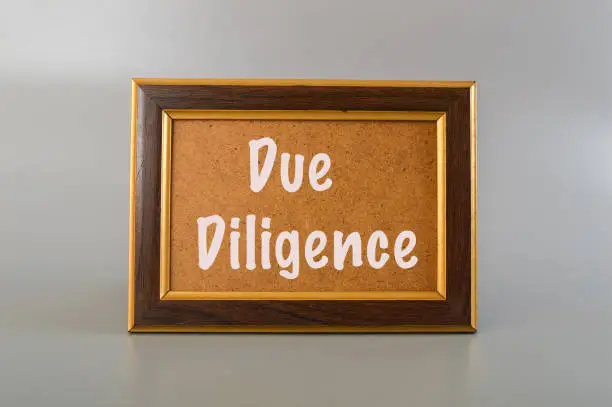 Photo of Brown frame written with DUE DILIGENCE.Due diligence refers to the process of conducting a thorough investigation and analysis of a company or investment opportunity before entering into a business transactio