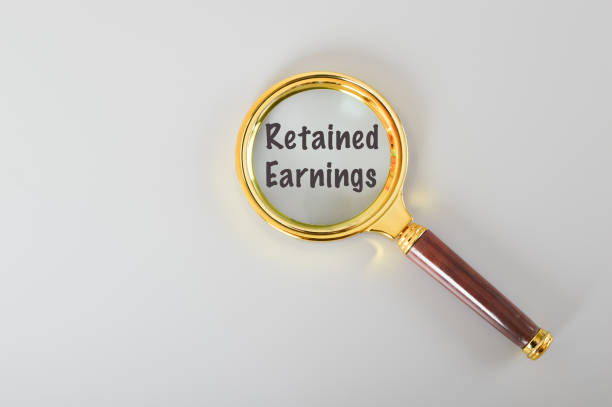 istock Magnifying glass written with RETAINED EARNINGS isolated on a grey background. 1486173762