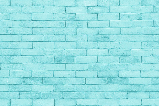 Brick wall painted with blue dark paint pastel calm tone texture background. Brickwork and stonework flooring interior rock old pattern clean concrete grid uneven bricks design stack backdrop.