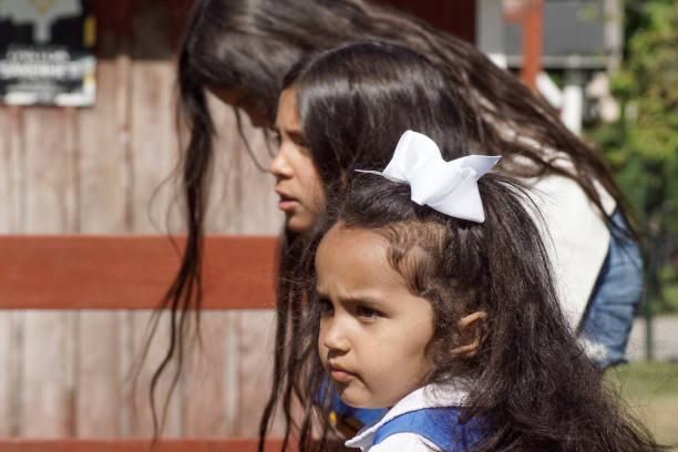 Side view of sisters standing outdoors during summer
