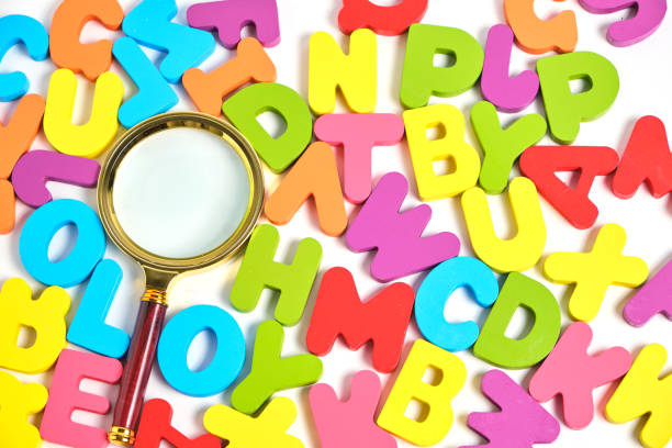 istock Magnifying glass and bright multicolored letters English alphabet. 1486183596