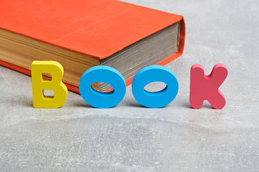 Word book is made of multicolored letters English alphabet. Against background paper book