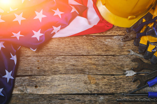 istock Flag America and construction tool on wooden background are illuminated by sunlight.Concept Labor Day first May. 1486183627