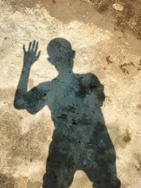 istock shadow of the man standing with hands up 1486185622