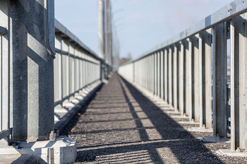 Pedestrian pavement safety barrier on the bridge. Sidewalk perspective