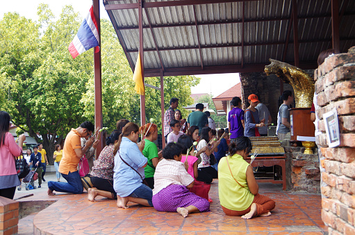 Bangkok,Thailand – April,30 2016:Many Thais have a habit of praying daily at home, at shrines and temples.\nEspecially in Buddhism, it is important to visit the temples on the full moon and new moon every month, and many people gather at temples on these days.\nIt is common for Thai people to put their hands together on a Buddha statue, called \