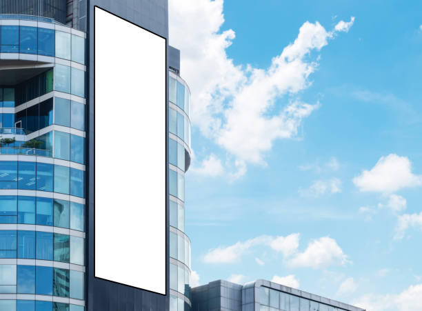 istock Mock up white large LED display vertical billboard on tower building with blue sky background. clipping path for mockup 1486206366