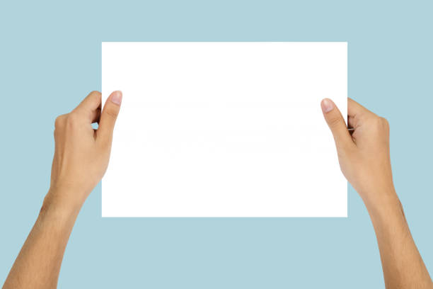 istock Hand holding Blank paper isolated on blue background. 1486207592