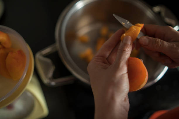 istock FFemale hands cutting fresh sweet peaches to make peach jam 1486210680