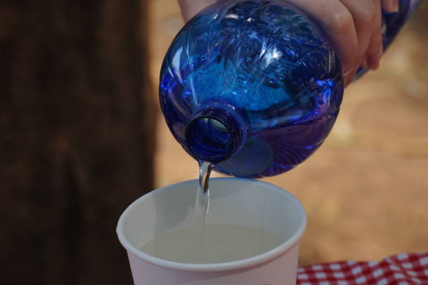 istock Clear Bottled water being poured into a  white paper cup 1486214480