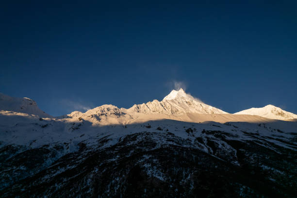 istock The mountain casts a shadow on the snow-covered peak 1486218059