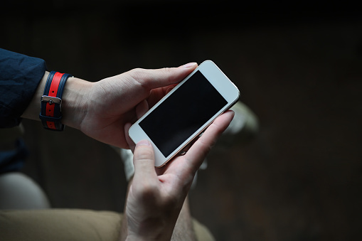 Close up of man's hands holding mock up smartphone, Empty screen of smartphone.