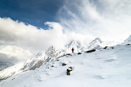Standing atop a snow-covered Nepalese mountain, the person gazes out at the breathtaking panoramic view, feeling a sense of awe and accomplishment at having conquered such a formidable peak. The crisp, thin air and the stunning vistas stretching out in all directions provide a humbling reminder of the power and majesty of nature.