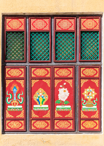 Frontal view of colorfully decorated closed window with embedded Buddhist motifs and ornaments