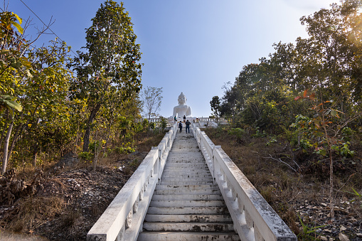 Tourists visiting Wat Phra That Mae Yen, or Big White Buddha is huge white Buddha stands on a hill with 353 steps, in Pai, popular tourist destination in Mae Hong Son, Thailand.