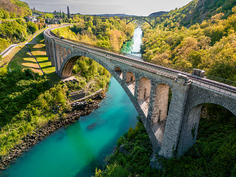 Aerial view at sunset of  the Solkan Bridge, which is the world's longest stone arch railroad bridge. 219.7-meter (721 ft) stone arch bridge (viaduct) over the Soča River near Nova Gorica in Slovenia.