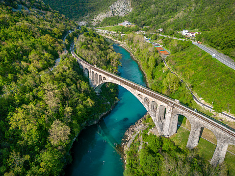 Aerial view at sunset of  the Solkan Bridge, which is the world's longest stone arch railroad bridge. 219.7-meter (721 ft) stone arch bridge (viaduct) over the Soča River near Nova Gorica in Slovenia.