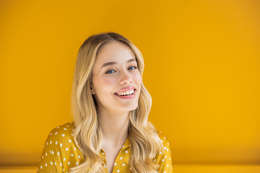 Beautiful blonde woman on yellow background.