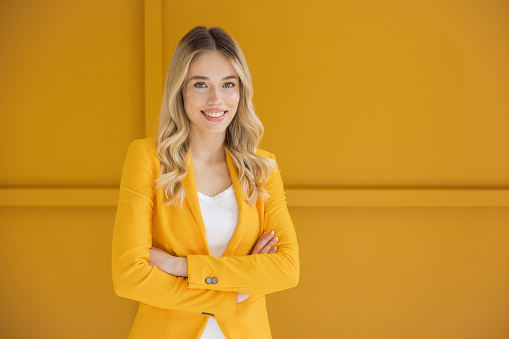 Beautiful blonde woman on yellow background.