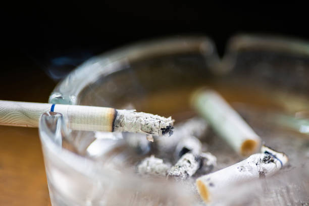 istock Ashtray with lit cigarette on a wooden table 1486225384