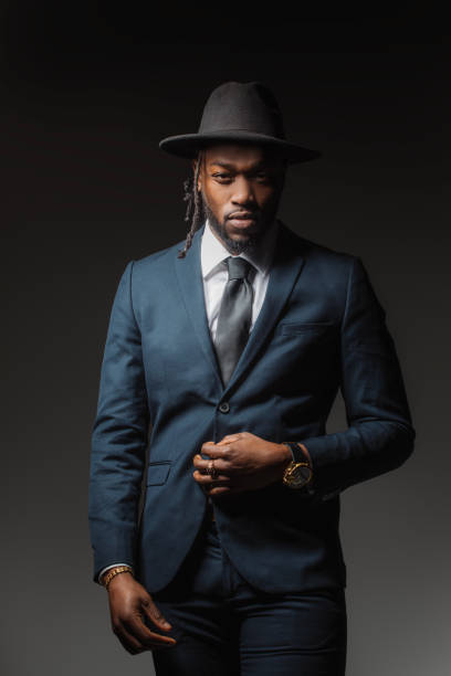 Handsome elegant black male posing for studio portrait wearing a hat stock photo