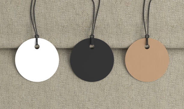 istock White, cardboard, black round tags mockup on fabric background. View directly above 1486227003