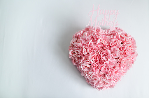 Design concept -A heart-shaped bouquet of carnations to celebrate Mother's Day placed on a white background
