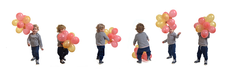 group of same baby boy playing with a air balloon standing on white background