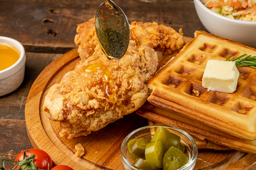 Syrup-drenched deep-fried chicken and waffles, close-up.