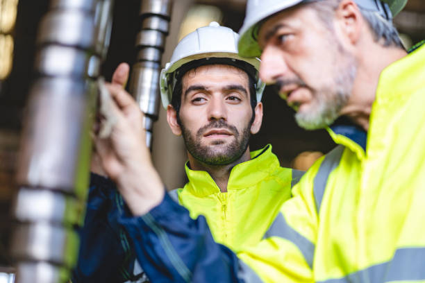 istock professional technician engineer with safety hard hat working to maintenance construction equipment in industrial factory, inspection man having manufacturing occupation job of production technology 1486232043