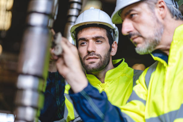 istock professional technician engineer with safety hard hat working to maintenance construction equipment in industrial factory, inspection man having manufacturing occupation job of production technology 1486234480