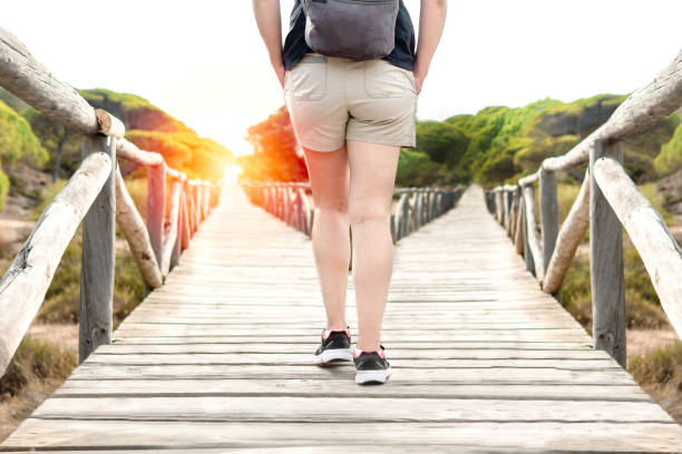 Woman choosing to take a light path or a dark path in a forest. Concept of decision making in life.