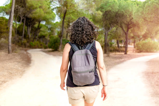 istock Woman choosing to take a light path or a dark path in a forest. Concept of decision making in life. 1486236963