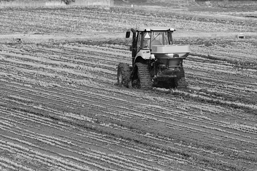 Obsolete and retired antique farm tractor on a snow covered hill in central Montana in western United States of America (USA). Light snow falling and foggy.