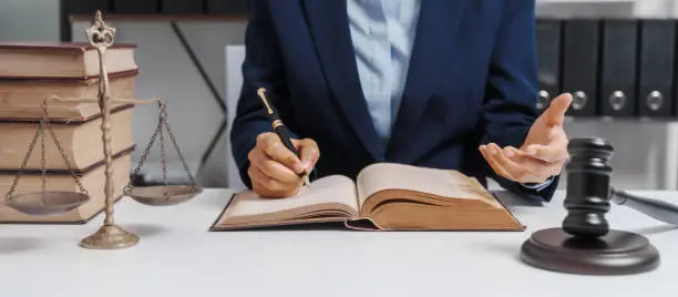 Photo of Young single female lawyer asian people in formal suit real estate working law book and contract documents, Arguments for Defense Strategy. Fight for Freedom. Supporting Evidence.