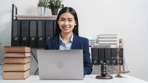 Photo of Young single female lawyer asian people in formal suit real estate working law book and contract documents, Arguments for Defense Strategy. Fight for Freedom. Supporting Evidence.