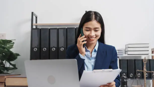 Photo of Young single female lawyer asian people in formal suit real estate working law book and contract documents, Arguments for Defense Strategy. Fight for Freedom. Supporting Evidence.