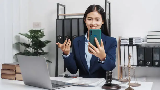 Photo of Young single female lawyer asian people in formal suit real estate working law book and contract documents, Arguments for Defense Strategy. Fight for Freedom. Supporting Evidence.